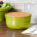 A green Fiesta Gusto Bowl filled with salad on a table.