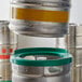 A Regency Keg Stacker holding a keg with a green lid.