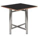 A black square Bon Chef dining table top with a wooden edge.