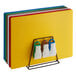 A rack holding 6 Choice color-coded cutting boards with yellow, blue, and green boards.