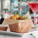 A rose gold rectangular mini fry basket filled with fried food on a plate next to a drink.