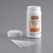 A close-up of a white Serim bottle with an orange label and a white cap filled with white Serim test strips.
