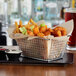 A rectangular mini fry basket filled with fries on a table.