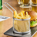 A basket of french fries and a burger in a stainless steel mini fry basket.