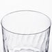 A close up of a Fineline clear plastic wine cup with a wavy pattern.