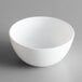 An Arcoroc white opal glass ramekin on a gray surface.