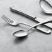 A silver Libbey Reserve Audrey salad fork on a marble surface.