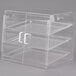 A clear plastic slanted display case with three shelves on a counter.