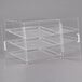 A clear plastic Cal-Mil bakery display case with three shelves.