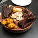A Town carved wooden Pu Pu platter with meat and vegetables on it.
