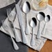 A group of Acopa stainless steel dinner forks on a table.