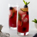 Two Chef & Sommelier Cabernet beverage glasses filled with red liquid garnished with mint.