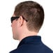 A man wearing black Cordova scratch-resistant safety glasses with gray lenses.