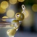 A close up of a martini glass filled with Belosa Blue Cheese Stuffed Queen Olives.