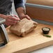 A person writing "Natural Kraft Freezer Paper" on a brown bag.