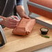A man using PeachTREAT Butcher Paper to wrap food