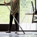 A woman holding a Lavex red microfiber spray mop.