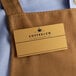 a brown apron with a name tag