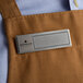A man wearing a Cawley silver rectangular name tag on a brown apron.