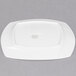 A white porcelain plate with a square shape on a white background.