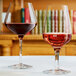 Two Chef & Sommelier Sublym wine glasses filled with red wine on a white table.