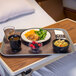 A Dinex Glasteel tray with a bowl of soup, a plate of food, and a bowl of berries on a table.
