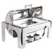 A silver metal Vollrath New York Roll Top Chafer with brass trim on a counter.