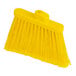 A close-up of a yellow Carlisle Sparta Duo-Sweep broom with long bristles.