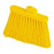 A close-up of a Carlisle yellow broom with long bristles and a yellow handle.