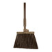 A brown Carlisle Sparta Duo-Sweep broom with a wooden handle and black bristles.