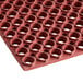 A red rubber Lavex anti-fatigue floor mat with holes.