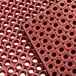 A red Lavex rubber anti-fatigue floor mat with holes in it.