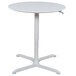 A white Luxor round pneumatic adjustable height cafe table with a metal base.