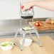 A tabletop-mounted fruit and vegetable dicer with a hand-operated lever and a grid blade for cutting produce into uniform pieces.