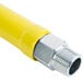 A yellow T&S gas appliance connector with silver metal ends.