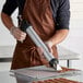 A man using a Backyard Pro Jerky Shooter to make jerky.