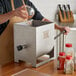 A man using a Backyard Pro meat mixer to pour spices into a metal container.