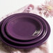 A stack of mulberry Fiesta appetizer plates on a pink napkin.