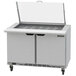 A Beverage-Air stainless steel commercial sandwich prep table with two drawers and a clear lid open.