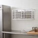 A Regency stainless steel wall mounted sheet pan rack.