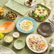 A table with Tuxton Artisan Geode Azure bouillon cups and plates of food.