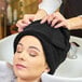 A woman with a black Monarch Brands hand towel on her head.