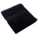 A folded black Monarch Brands True Colors hand towel on a white background.