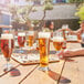 Arcoroc Linz footed pilsner glasses filled with beer on a table in a brewery tasting room.