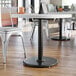 A Lancaster Table & Seating black cast iron table base in a restaurant dining area.