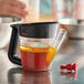 a measuring cup with a brown liquid in it