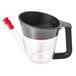 An OXO clear plastic fat separator with a red handle.