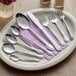 A plate with silverware and a Choice Bethany stainless steel demitasse spoon on it.