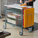 A person cutting food on a Metro PrepMate multistation cart.