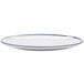 A close up of a GET Settlement Bistro white melamine dinner coupe plate with a cobalt blue rim.